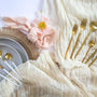 Flatlay of gold plated cutlery set on top of table runners