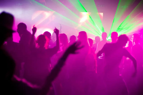 Disco-themed wedding reception with neon lights and dancing guests