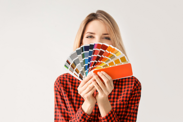 young woman on white background holding colour palette cards