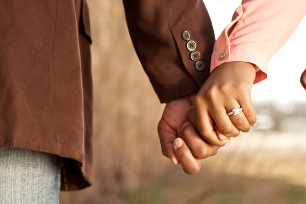 closeup of engaged couple holding hands