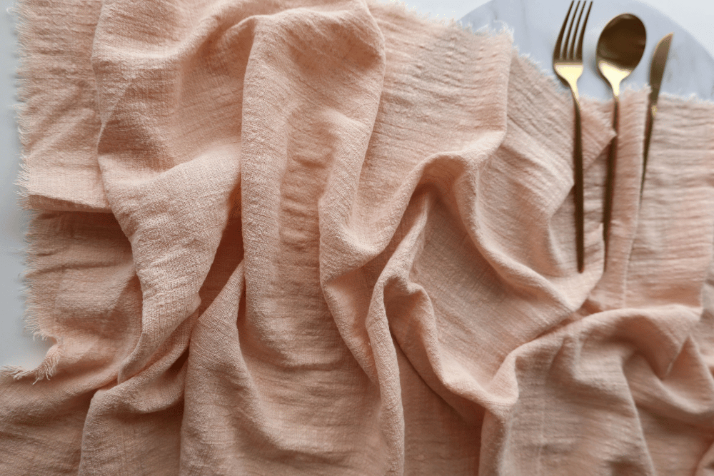 peach cotton table runner with gold cutlery