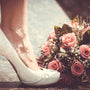 Vintage-looking image of wedding shoes and a bouquet of flowers
