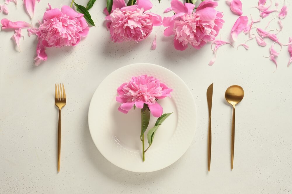 Feminine tablescape with pink peonies and gold cutlery