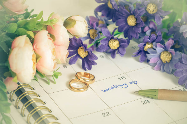 wedding reminder on calendar with rings and flowers